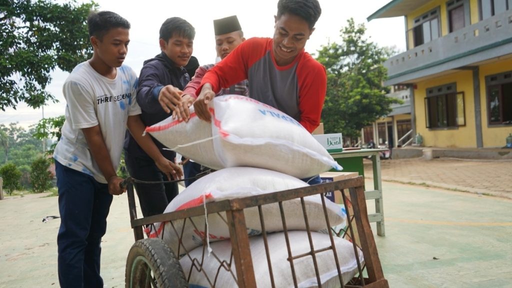 Para Santri sedang mengangkut bantuan beras dari Ruang Baik. (doc Ruang Baik)